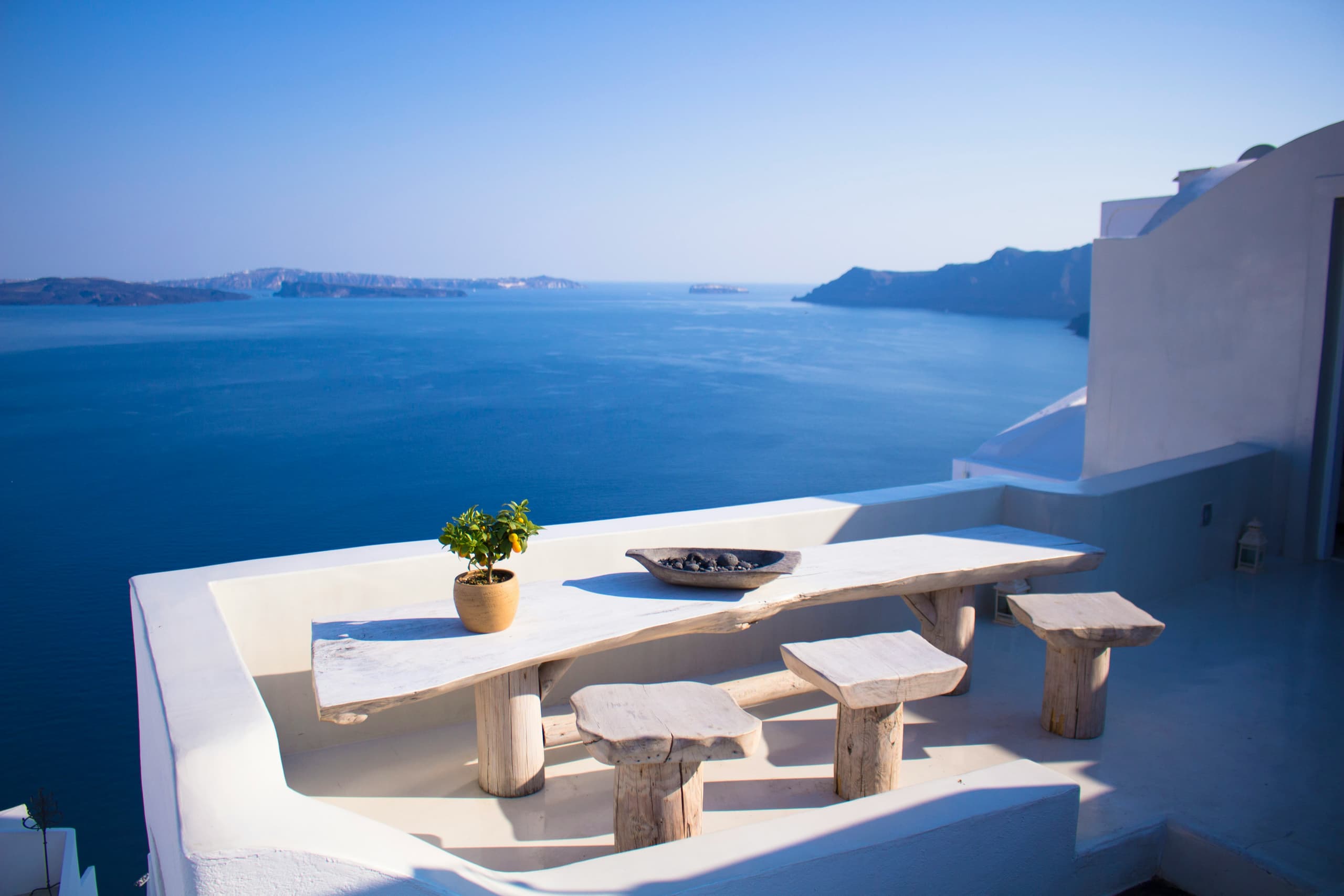 A whitewashed terrace and table overlooking the Aegean